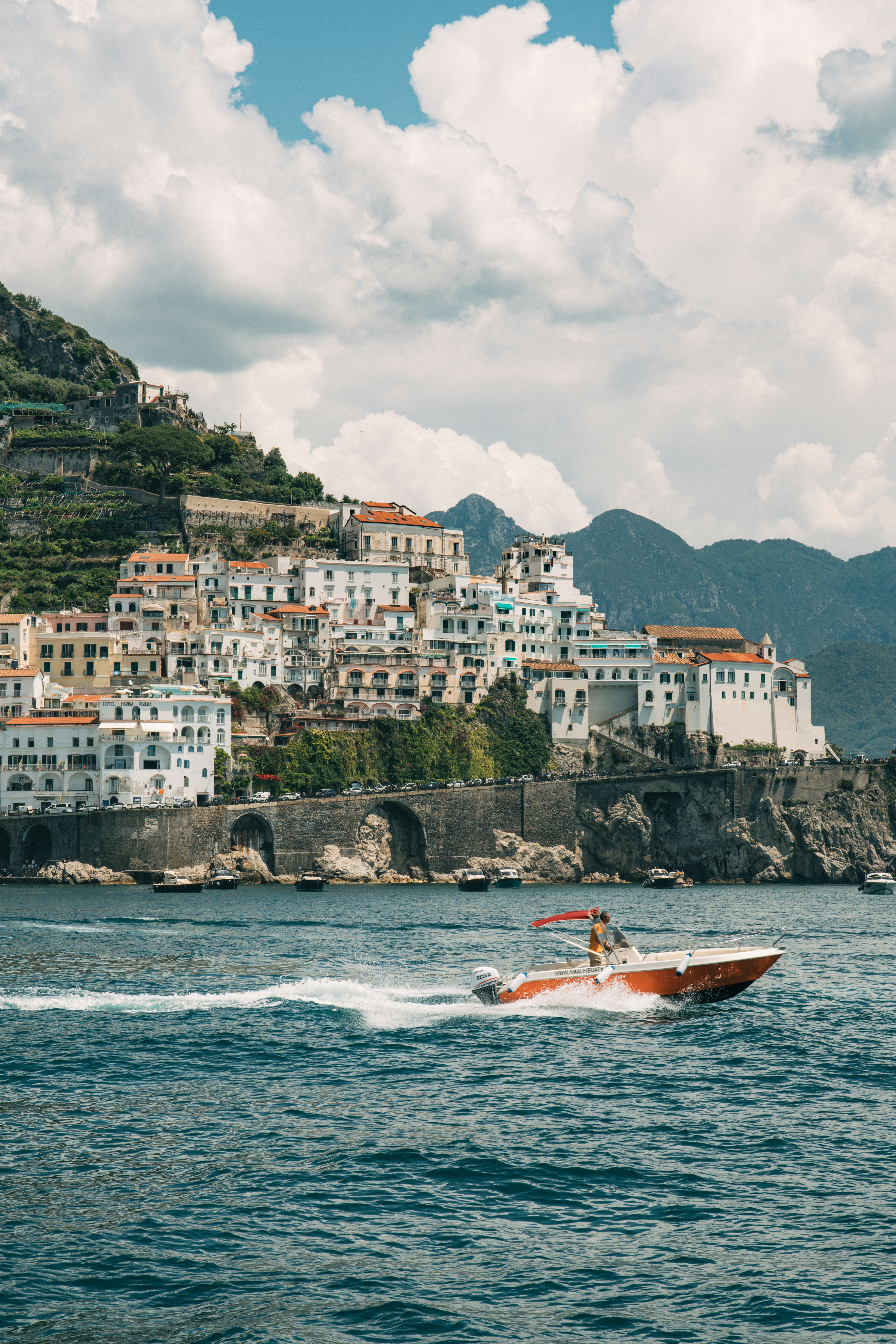 Amalfi coastline town with a boat passing in the foreground