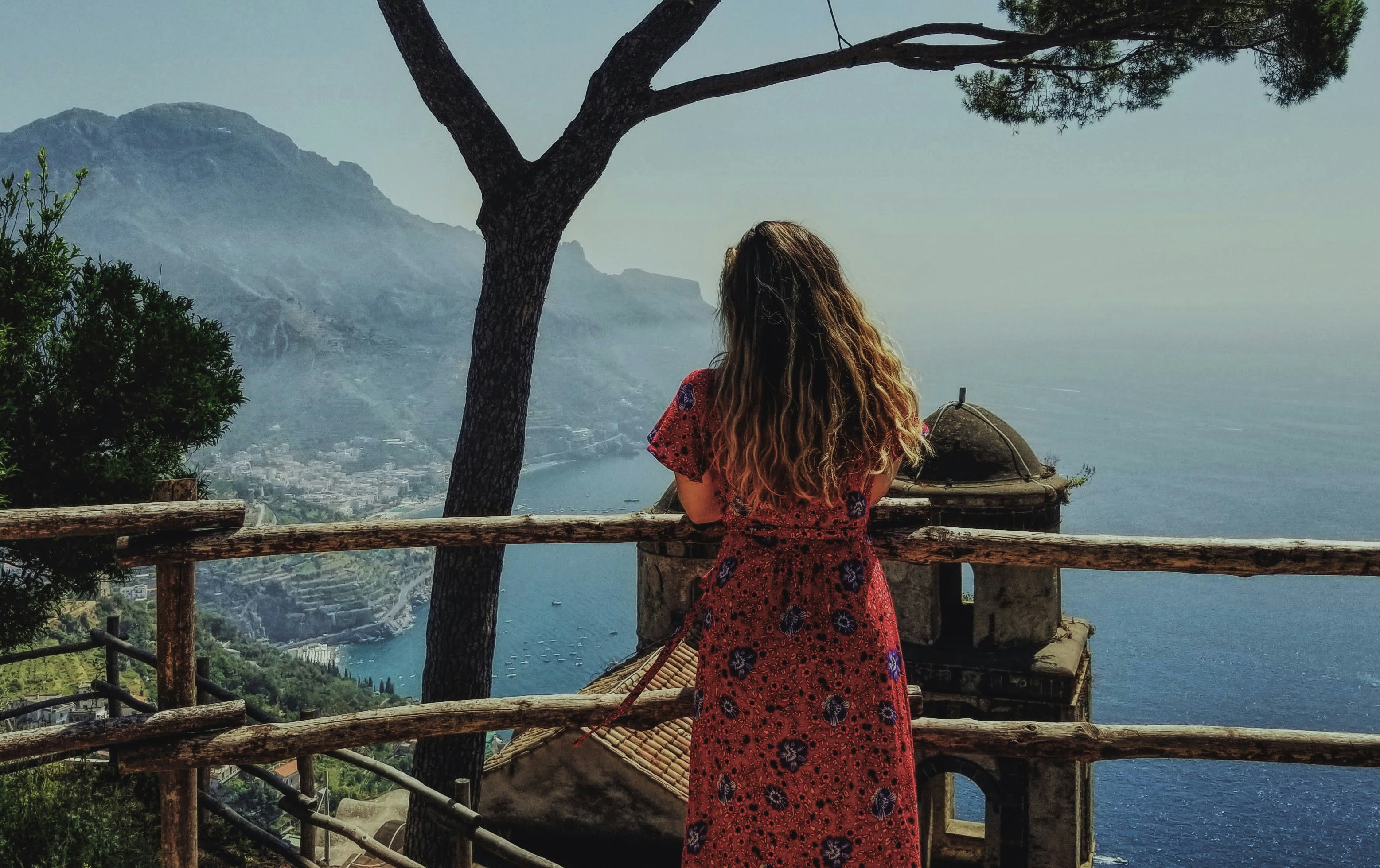A traveler looking out over the Amalfi Coast from a garden terrace in Ravello